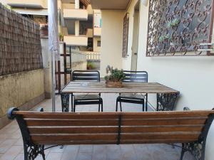 a wooden table and chairs with a table and a bench at La Casetta di Silvia in Piano di Mommio