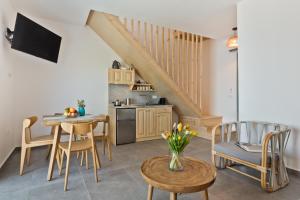 a living room with a table and chairs and a kitchen at Myrthea Luxury Villas in Karpathos