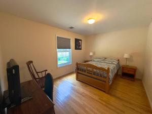 a bedroom with a bed and a table and a television at Lovely 2 Bedrooms Apartment in Scotch Plains