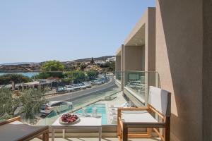 a balcony with chairs and a view of a street at Beachfront Villa Edem Dedicated Beach Space - Heated Pool in Agios Nikolaos