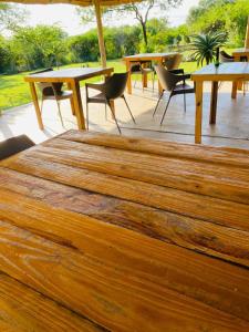 a large wooden rug on a patio with tables and chairs at Elephant Corridor Lodge in Hluhluwe