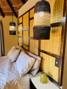 a bedroom with a bed and two lamps and a table at Elephant Corridor Lodge in Hluhluwe