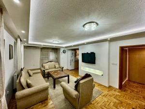 a living room with two couches and a tv at Stay and Chill house in Doglodi