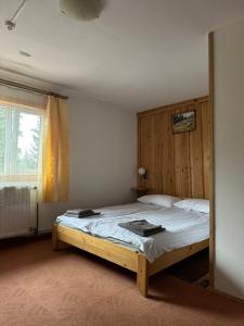 a bedroom with a bed with a wooden headboard at Plai in Dragobrat