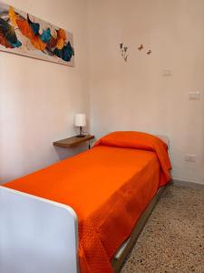 a bedroom with a bed with an orange blanket at La Ginestra in Roccascalegna