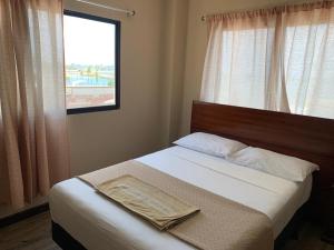 a small bedroom with a bed with a window at Hotel Belamar in La Libertad