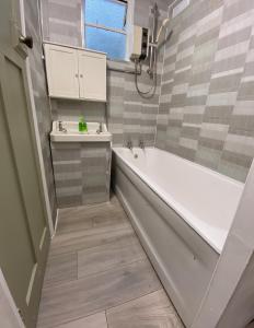 a bathroom with a tub and a sink at Lime Cottage in Mountain Ash