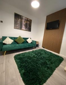 a living room with a green couch and a green rug at Lime Cottage in Mountain Ash