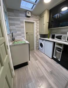 a kitchen with a sink and a washing machine at Lime Cottage in Mountain Ash +26 photos