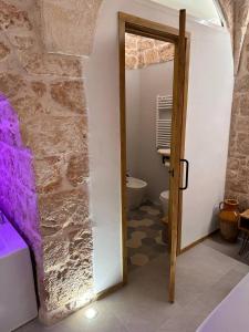 a bathroom with a door open to a bathroom with a toilet at Primus Suite in Ceglie Messapica