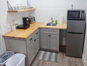 a small kitchen with a sink and a microwave at Vermont Suites in South Burlington
