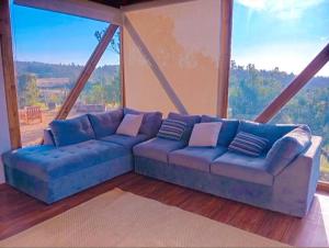 a blue couch in a room with a large window at Soul House- Colinas y Mar in Navidad +3 photos
