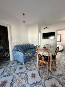 a living room with a blue couch and a table at Villetta Roberto Le Macine di Charme - Pugnochiuso Resort in Vieste