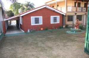 una casa de ladrillo rojo con un patio delante en Recanto Boa Ideia, en Campo Alegre