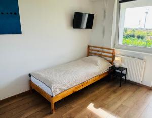 a small bedroom with a bed and a window at Na Poczatku - Apartamenty in Darłowo