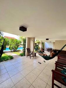 Un hombre acostado en una hamaca en una sala de estar. en Casa de praia no Icaraí, en Caucaia