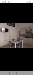 a kitchen with a table and chairs in a kitchen at appartamento gioioso in Castellammare del Golfo
