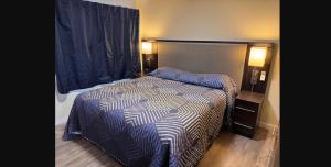 a bedroom with a bed with a blue and white comforter at The Lodge Tulelake in Tulelake