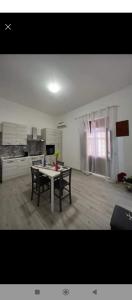 a living room with a table and a kitchen at appartamento gioioso in Castellammare del Golfo