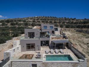a house on a hill with a swimming pool at Villas Paradise in Kalamaki by South Cretan Villas in Kalamaki