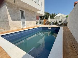 a swimming pool in front of a house at Vila Regina Apartment Rex with Swimming Pool in Jezera