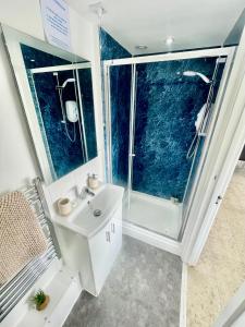 a bathroom with a white sink and a shower at City Centre Cozy Studio flat Second Floor in Cambridge +5 photos