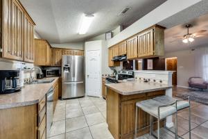 une grande cuisine avec des placards en bois et des appareils en acier inoxydable dans l'établissement Cowboy Chic, à Watauga 12 autres photos