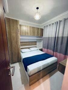 une chambre avec un lit et un lustre dans l'établissement شاليه بورتو جولف العلمين الساحل الشمالي - porto golf, à El Alamein