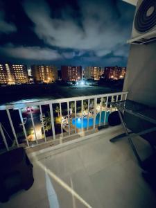 un balcon avec vue sur une ville la nuit dans l'établissement شاليه بورتو جولف العلمين الساحل الشمالي - porto golf, à El Alamein 7 autres photos