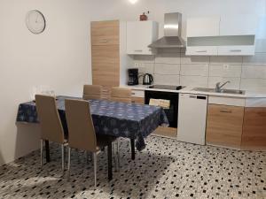 eine Küche mit einem Tisch mit Stühlen und einem Waschbecken in der Unterkunft Holiday House Palma in Dobrinj