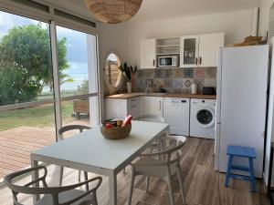 a kitchen with a table and chairs and a refrigerator at Blueshell in Saint-François