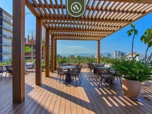 a wooden deck with tables and chairs on a building at New 1 BR Condo with Amazing Rooftop Pool - Jacuzzi in Bucerías