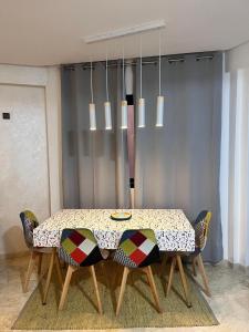 une salle à manger avec une table, des chaises et un lustre dans l'établissement Nour 5, à Marrakech 4 autres photos