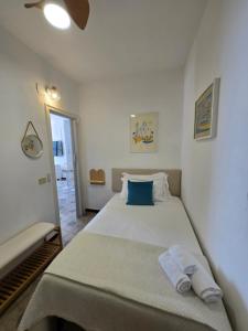 - une chambre avec un grand lit blanc et un oreiller bleu dans l'établissement Divina Seaside Suite Ischia, à Ischia