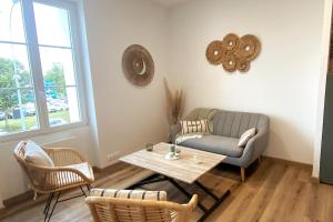 uma sala de estar com um sofá e uma mesa em Appartement vue Port em Perros-Guirec