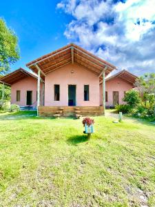 a house with a large yard in front of it at Chalés Costa Amar in Porto Seguro