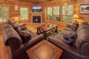 een woonkamer met banken en een open haard in een huisje bij Lumberjack Lodge Holiday home in Gatlinburg