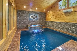 een zwembad in een huis met een stenen muur bij Lumberjack Lodge Holiday home in Gatlinburg +13 foto's