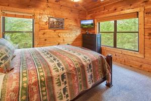 ein Schlafzimmer mit einem Bett und einem TV in einer Blockhütte in der Unterkunft Fire in the Sky Holiday home in Gatlinburg