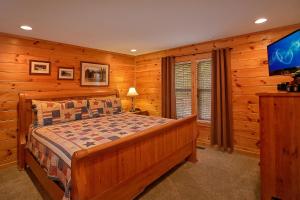 een slaapkamer met een bed en een flatscreen-tv bij Bearfoot Memories Holiday home in Gatlinburg +37 foto's
