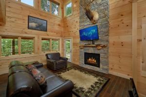 a living room with a couch and a fireplace at Poolin Around in Waldens Creek