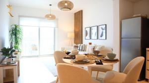 a kitchen and dining room with a table and chairs at Cozy 1BR Apartment on Yas Island - Relaxing Stay Near Yas Mall in Abu Dhabi +35 photos