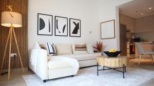 a living room with a white couch and a table at Cozy 1BR Apartment on Yas Island - Relaxing Stay Near Yas Mall & Ferrari World in Abu Dhabi