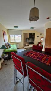 a living room with a table and red chairs at Jauke Departamentos in Ushuaia