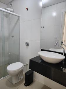 a bathroom with a white toilet and a sink at Apartamento Balneário Camboriú in Balneário Camboriú