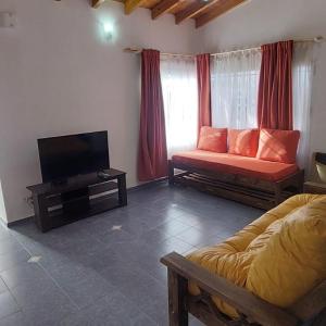a living room with a couch and a flat screen tv at Casa bosque de Sol in Malargüe