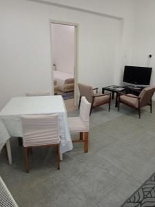 un soggiorno con tavolo, sedie e pianoforte di City Central a Paraćin