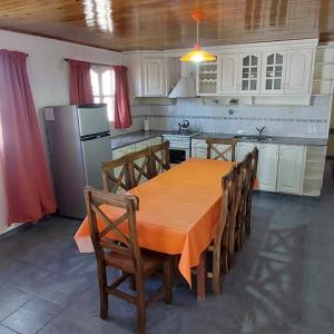 a kitchen with a table with chairs and a refrigerator at Casa bosque de Sol in Malargüe