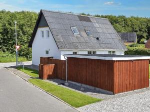 a white house with a wooden fence in front of it at 4 star holiday home in Farsø-By Traum in Års