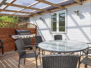 a patio with a table and chairs and a grill at 4 star holiday home in Gedsted-By Traum in Gedsted